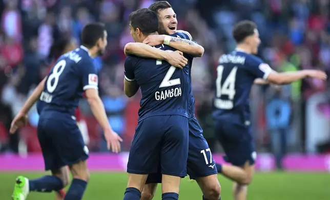 Bochum's Cristian Gamboa, center left, and Tom Krauss celebrate after the German Bundesliga soccer match between Bayern Munich and VfL Bochum at the Allianz Arena in Munich, Germany, Saturday, March 8, 2025. (Sven Hoppe/dpa via AP)
