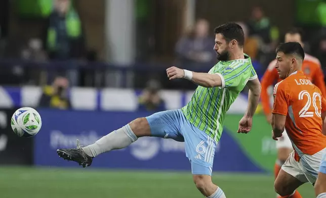 Seattle Sounders midfielder Joao Paulo, left, reaches for the ball against Houston Dynamo midfielder Nicolás Lodeiro, right, during the first half of an MLS soccer match Saturday, March 22, 2025, in Seattle. (AP Photo/Lindsey Wasson)