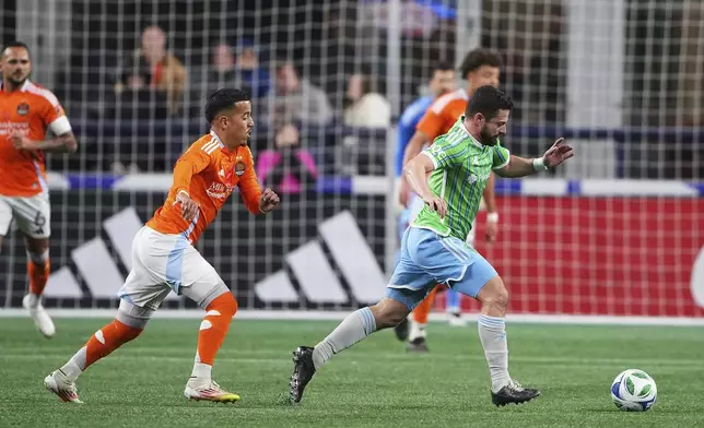 Houston Dynamo midfielder Amine Bassi, left, chases Seattle Sounders midfielder Joao Paulo, right, during the first half of an MLS soccer match Saturday, March 22, 2025, in Seattle. (AP Photo/Lindsey Wasson)