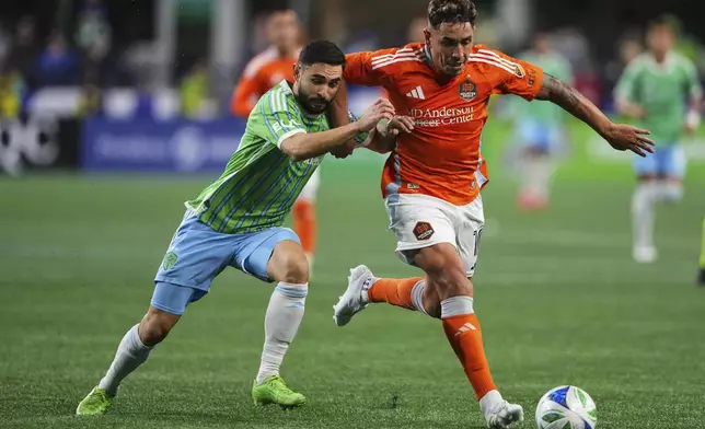 Seattle Sounders midfielder Alex Roldan, left, vies for the ball against Houston Dynamo forward Ezequiel Ponce, right, during the first half of an MLS soccer match Saturday, March 22, 2025, in Seattle. (AP Photo/Lindsey Wasson)