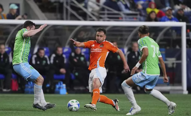 Houston Dynamo midfielder Nicolás Lodeiro, center, looks to pass the ball between Seattle Sounders midfielder João Paulo, left, and midfielder Danny Leyva, right, during the first half of an MLS soccer match Saturday, March 22, 2025, in Seattle. (AP Photo/Lindsey Wasson)