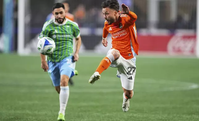 Houston Dynamo midfielder Sebastian Kowalczyk leaps for the ball against Seattle Sounders midfielder Alex Roldan, left, during the first half of an MLS soccer match Saturday, March 22, 2025, in Seattle. (AP Photo/Lindsey Wasson)