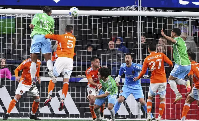 Houston Dynamo goalkeeper Jimmy Maurer (1) looks on as Seattle Sounders defender Jon Bell (15) tries to head the ball in from a corner kick during the first half of an MLS soccer match Saturday, March 22, 2025, in Seattle. (AP Photo/Lindsey Wasson)