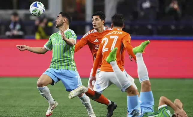 Seattle Sounders midfielder Cristian Roldan looks for the ball against Houston Dynamo defender Franco Escobar, second from left, during the first half of an MLS soccer match Saturday, March 22, 2025, in Seattle. (AP Photo/Lindsey Wasson)
