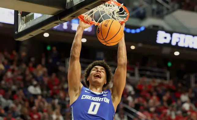Creighton's Jasen Green (0) dunks during the second half against Louisville in the first round of the NCAA college basketball tournament in Lexington, Ky., Thursday, March 20, 2022. (AP Photo/James Crisp)