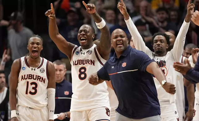 The Auburn bench celebrates during the second half in the Sweet 16 of the NCAA college basketball tournament against Michigan, Saturday, March 29, 2025, in Atlanta. (AP Photo/George Walker IV)