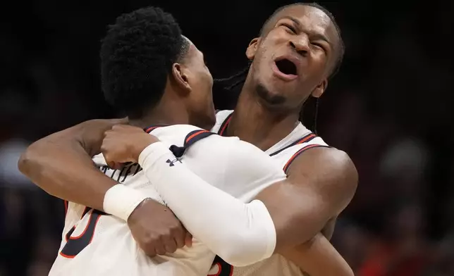 Auburn's Tahaad Pettiford, left, and Miles Kelly (13) celebrate a win over Michigan State after the Elite Eight of the NCAA college basketball tournament, Sunday, March 30, 2025, in Atlanta. (AP Photo/Brynn Anderson)