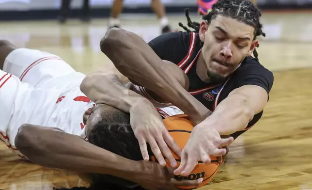 SIU Edwardsville forward Kyle Thomas, right, dives for a loose ball against Houston forward Joseph Tugler, left, during the first half in the first round of the NCAA college basketball tournament, Thursday, March 20, 2025, in Wichita, Kan. (AP Photo/Travis Heying)