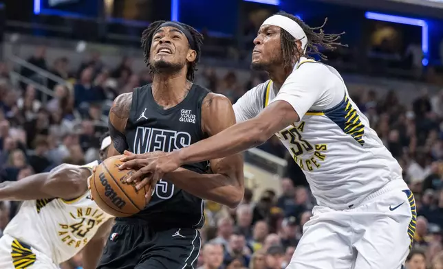Indiana Pacers center Myles Turner (33) attempts to stop a shot by Brooklyn Nets center Nic Claxton (33) during the first half of an NBA basketball game in Indianapolis, Saturday, March 22, 2025. (AP Photo/Doug McSchooler)