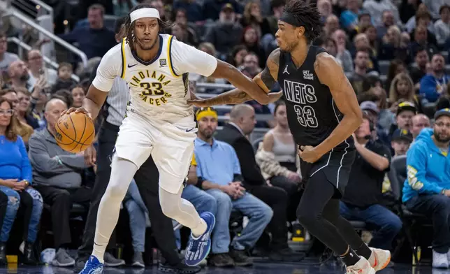 Indiana Pacers center Myles Turner (33) is defended by Brooklyn Nets center Nic Claxton (33) during the second half of an NBA basketball game in Indianapolis, Saturday, March 22, 2025. (AP Photo/Doug McSchooler)