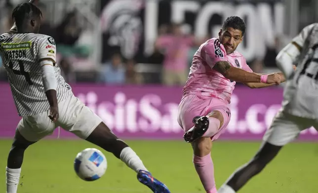 Inter Miami forward Luis Suárez, right, kicks to score a goal during the second half of a CONCACAF Champions Cup soccer match against Cavalier Thursday, March 6, 2025, in Fort Lauderdale, Fla. (AP Photo/Lynne Sladky)
