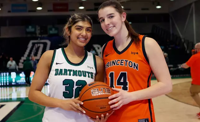 Dartmouth's Annika Jiwani, left, and Princeton's Emily Eadie, two of six women from Kobe Bryant’s Mamba Academy going through their first experience with college basketball, pose before an NCAA college basketball game, Saturday, March 1, 2025, in Hanover, N.H. (AP Photo/Mary Schwalm)