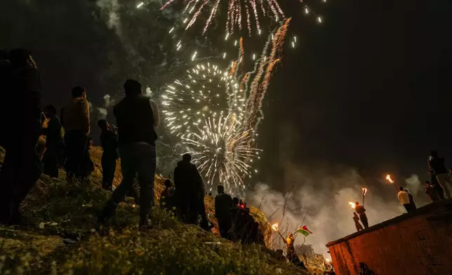 Iraqi Kurds holding lit torches walk up a mountain during a procession to celebrate their Nowruz, the Persian New Year, in Akra, in Iraq's northern autonomous Kurdish region, Thursday, March 20, 2025. (AP Photo/Hadi Mizban)