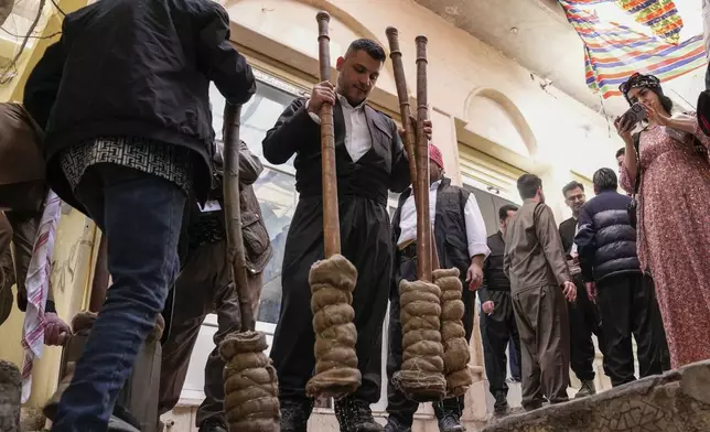 Men store torches to be used for the Persian New Year or Nowruz celebrations, in Akra, in Iraq's northern autonomous Kurdish region, Thursday, March 20, 2025. (AP Photo/Hadi Mizban)