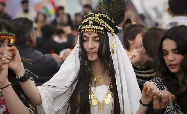 A Syrian Kurdish girl wearing traditional clothing dances during a celebration of Nowruz, Kurdish New Year, in Qamishli, northeastern Syria, Friday March 21, 2025. (AP Photo/Baderkhan Ahmad)
