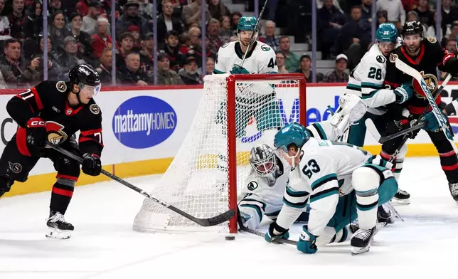 Ottawa Senators' Ridly Greig (71) looks for a wraparound chance as San Jose Sharks' Ty Dellandrea (53) defends with goaltender Vitek Vanecek (41) during second period NHL hockey action in Ottawa, on Saturday, March 1, 2025. (Justin Tang/The Canadian Press via AP)