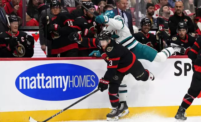 San Jose Sharks' Ty Dellandrea (53) crashes into Ottawa Senators' Nick Jensen (3) along the bench during first period NHL hockey action in Ottawa, on Saturday, March 1, 2025. (Justin Tang/The Canadian Press via AP)