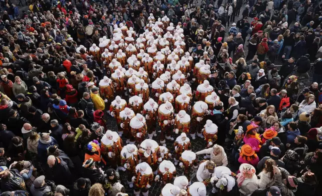 The Gilles of Binche wear their traditional wax masks as they attend Carnival celebrations in Binche, Belgium, Tuesday, March 4, 2025. (AP Photo/Omar Havana)