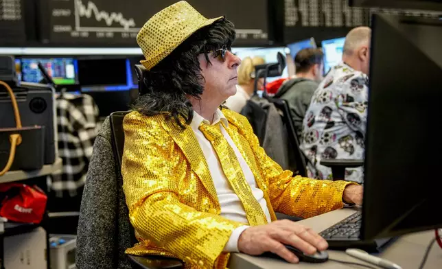 A broker watches his screens at the stock market in Frankfurt, Germany, on the traditional Carnival Tuesday, March 4, 2025. (AP Photo/Michael Probst)