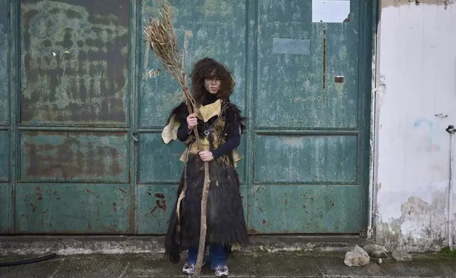 Hara Papageorgiou, 12, poses for a portrait, dressed in animal skins and heavy bronze bells, as part of carnival celebrations in Distomo, a village in central Greece, on Monday, March 3, 2025. (AP Photo/Petros Giannakouris)