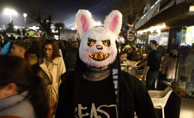 A disguised man walks through a street during the main carnival parade in North Macedonia's southeastern town of Strumica, marking the beginning of the Easter fasting period, late Saturday, March 1, 2025. (AP Photo/Boris Grdanoski)