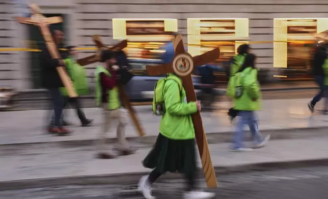 Volunteers carry wooden crosses near St. Peter's Square in Rome, Italy, Friday, March 7, 2025. (AP Photo/Francisco Seco)