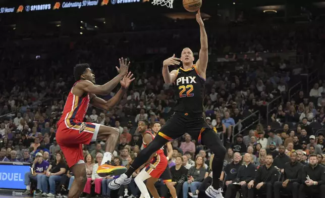 Phoenix Suns center Mason Plumlee (22) drives past New Orleans Pelicans center Yves Missi during the first half of an NBA basketball game, Friday, Feb. 28, 2025, in Phoenix. (AP Photo/Rick Scuteri)