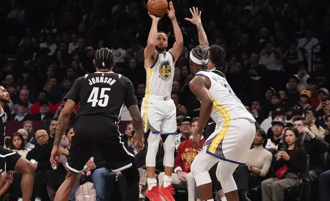 Golden State Warriors' Stephen Curry (30) shoots over Brooklyn Nets' Keon Johnson (45) during the second half of an NBA basketball game Thursday, March 6, 2025, in New York. (AP Photo/Frank Franklin II)