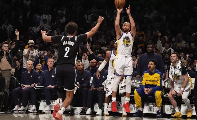 Golden State Warriors' Stephen Curry (30) shoots a three-point shot over Brooklyn Nets' Cameron Johnson (2) during the second half of an NBA basketball game Thursday, March 6, 2025, in New York. (AP Photo/Frank Franklin II)