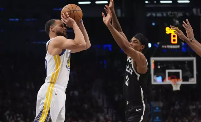Golden State Warriors' Stephen Curry (30) shoots a three-point shot over Brooklyn Nets' Nic Claxton (33) during the second half of an NBA basketball game Thursday, March 6, 2025, in New York. (AP Photo/Frank Franklin II)