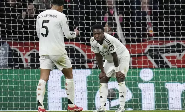 Real Madrid's Vinicius Junior, right, reacts after missing a penalty kick during the Champions League round of 16, second leg, soccer match between Atletico Madrid and Real Madrid at the Metropolitano stadium in Madrid, Spain, Wednesday, March 12, 2025. (AP Photo/Bernat Armangue)