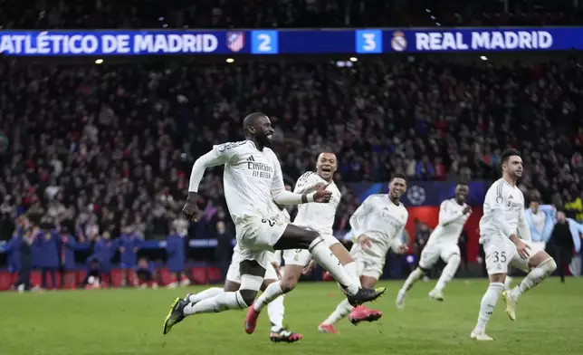 Real Madrid players celebrate after winning the penalty shootout during the Champions League round of 16, second leg, soccer match between Atletico Madrid and Real Madrid at the Metropolitano stadium in Madrid, Spain, Wednesday, March 12, 2025. (AP Photo/Bernat Armangue)
