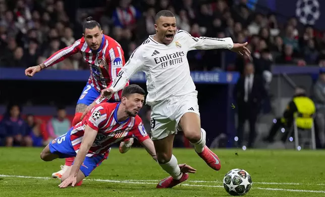 Atletico Madrid's Clement Lenglet, center, fouls Real Madrid's Kylian Mbappe during the Champions League round of 16, second leg, soccer match between Atletico Madrid and Real Madrid at the Metropolitano stadium in Madrid, Spain, Wednesday, March 12, 2025. (AP Photo/Manu Fernandez)