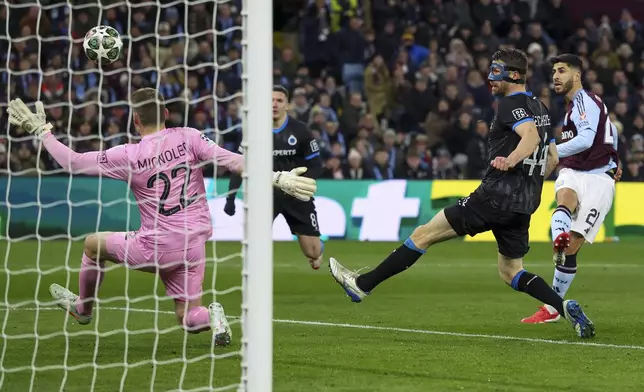 Aston Villa's Marco Asensio, right, scores the opening goal during the Champions League round of 16 second leg soccer match between Aston Villa and Club Brugge at the Villa Park stadium in Birmingham, England, Wednesday, March 12, 2025. (AP Photo/Darren Staples)