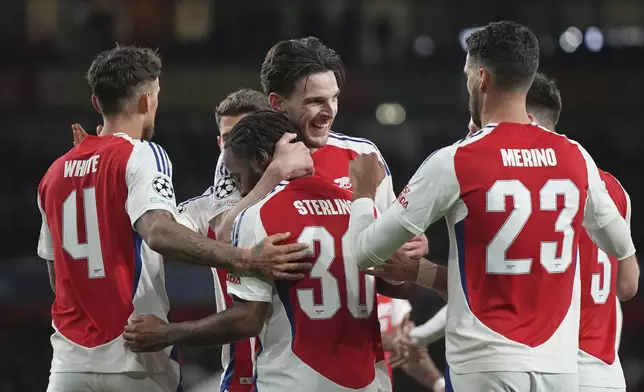 Arsenal's Declan Rice, centre, celebrates with teammates after scoring his side's second goal during the Champions League round of 16 second leg soccer match between Arsenal FC and PSV Eindhoven at the Arsenal stadium in London, England, Wednesday, March 12, 2025. (AP Photo/Alastair Grant)