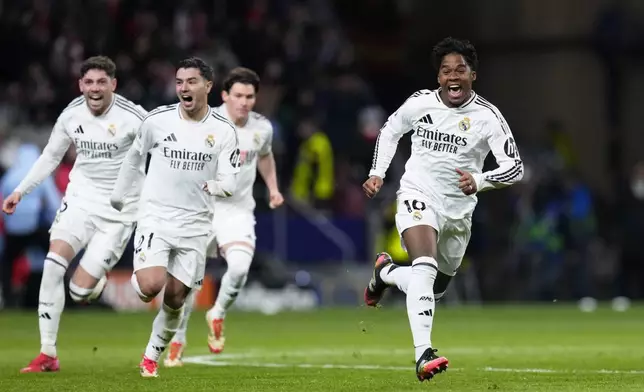 Real Madrid's Endrick, right, and his teammates run celebrating after a penalty shootout at the end of the Champions League round of 16, second leg, soccer match between Atletico Madrid and Real Madrid at the Metropolitano stadium in Madrid, Spain, Wednesday, March 12, 2025. (AP Photo/Manu Fernandez)
