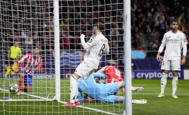 Players react after Atletico Madrid's Conor Gallagher, on the ground, scored the opening goal during the Champions League round of 16, second leg, soccer match between Atletico Madrid and Real Madrid at the Metropolitano stadium in Madrid, Spain, Wednesday, March 12, 2025. (AP Photo/Manu Fernandez)