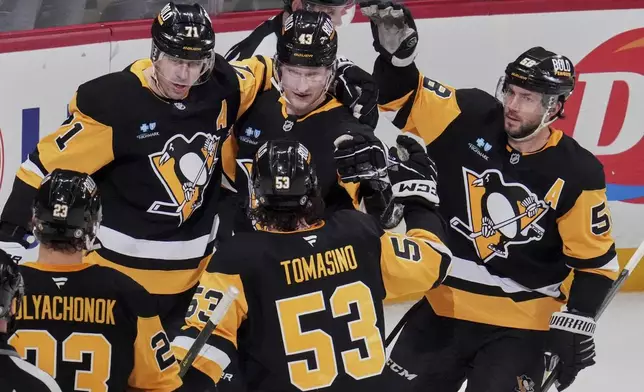 Pittsburgh Penguins' Danton Heinen (43) celebrates with teammates after scoring during the first period of an NHL hockey game against the New Jersey Devils in Pittsburgh, Saturday, March 15, 2025. (AP Photo/Gene J. Puskar)