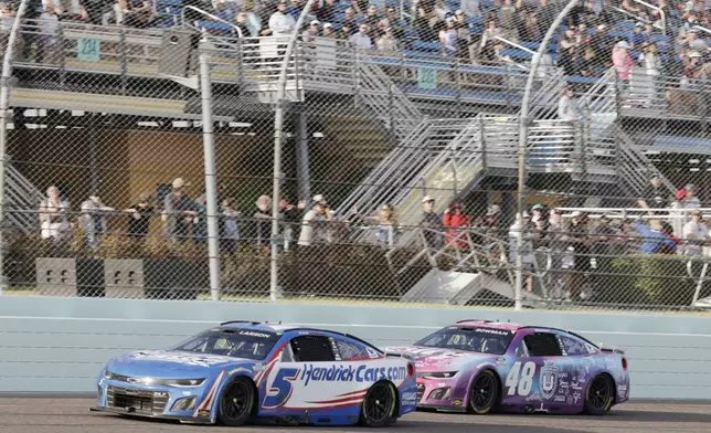 Kyle Larson (5) passes Bubba Wallace (23) to take the lead during a NASCAR Cup Series auto race at Homestead-Miami Speedway in Homestead, Fla., Sunday, March 23, 2025. (AP Photo/Terry Renna)