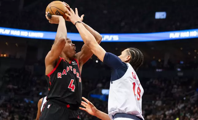 Toronto Raptors guard Scottie Barnes (4) passes the ball over Washington Wizards forward Kyshawn George (18) during the first half of NBA action in Toronto on Saturday, March 8, 2025. THE CANADIAN PRESS/Thomas Skrlj/The Canadian Press via AP)