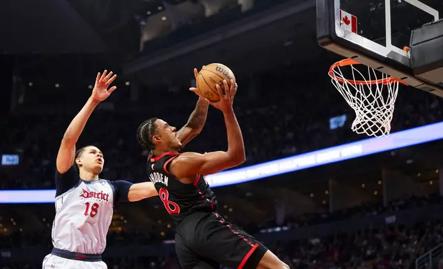 Toronto Raptors guard Jared Rhoden (8) drives the net against defending Washington Wizard forward Kyshawn George (18) during the first half of NBA action in Toronto on Saturday, March 8, 2025. THE CANADIAN PRESS/Thomas Skrlj/The Canadian Press via AP)