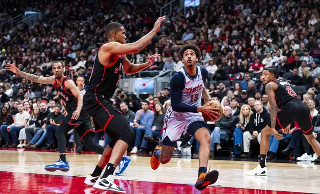 Washington Wizards guard Jordan Poole (13) drives the ball past Toronto Raptors centre Orlando Robinson (21) during the second half of NBA action in Toronto on Saturday, March 8, 2025. (Thomas Skrlj/The Canadian Press via AP)