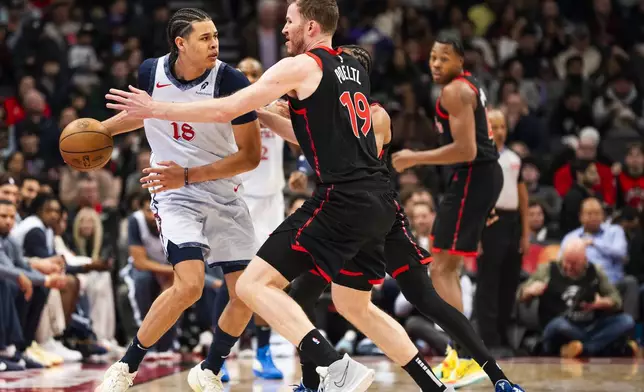 Washington Wizards forward Kyshawn George (18) is defended by Toronto Raptors centre Jakob Poeltl (19) during the first half of NBA action in Toronto on Saturday, March 8, 2025. (Thomas Skrlj/The Canadian Press via AP)