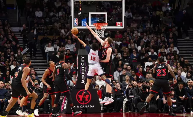 Toronto Raptors centre Jakob Poeltl defends against Washington Wizards guard Jordan Poole (13) during the first half of NBA action in Toronto on Saturday, March 8, 2025. (Thomas Skrlj/The Canadian Press via AP)