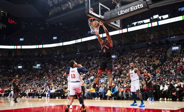 Toronto Raptors guard Scottie Barnes (4) dunks the ball past defending Washington Wizards guard Jordan Poole during the first half of NBA action in Toronto on Saturday, March 8, 2025. (Thomas Skrlj/The Canadian Press via AP)