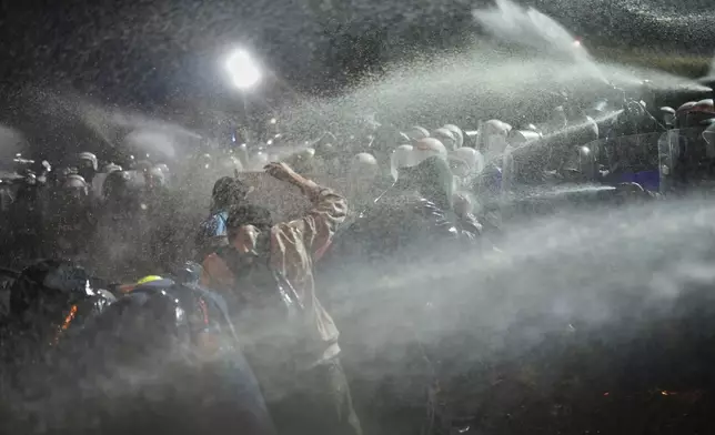 Riot police use pepper spray to clear protesters during a protest against the arrest of Istanbul's Mayor Ekrem Imamoglu, in Istanbul, Turkey, Saturday, March 22, 2025. (AP Photo/Francisco Seco)