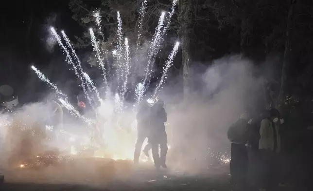 A firework launched by protesters as they clash with riot police during a protest against the arrest of Istanbul's Mayor Ekrem Imamoglu, in Istanbul, Turkey, Saturday, March 22, 2025. (AP Photo/Francisco Seco)