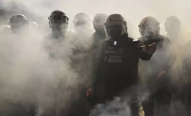 Riot police clash with protesters during a protest against the arrest of Istanbul's Mayor Ekrem Imamoglu, in Istanbul, Turkey, Saturday, March 22, 2025. (AP Photo/Francisco Seco)