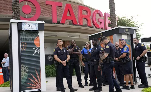 FILE - Police stand outside a Target store as protesters across the street demonstrate against Pride displays in the store on June 1, 2023, in Miami. (AP Photo/Lynne Sladky, File)