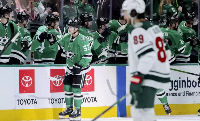 Dallas Stars center Wyatt Johnston (53) celebrates with his team after scoring in the second period of an NHL hockey game against the Minnesota Wild in Dallas, Monday, March 24, 2025. (AP Photo/Gareth Patterson)